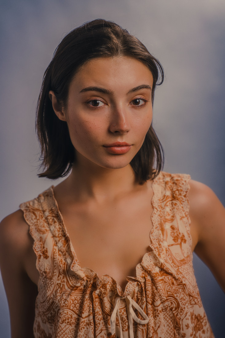 Alla in a textured peach sleeveless top, photographed from the shoulders up.
